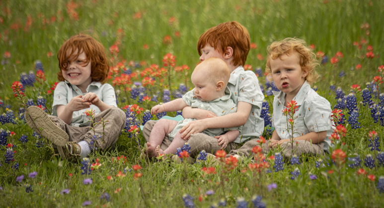 Siblings (left to right) Brantley Pogue, 5, Deacon Pogue, 7-months-old, Aiden Pogue, 7 (holding Deacon) and Calvin Pogue, 3, enjoyed sitting among the wildflowers after collecting their eggs during the annual Easter egg hunt at Georgetown Church of the Nazarene on Saturday, March 30, 2024.
