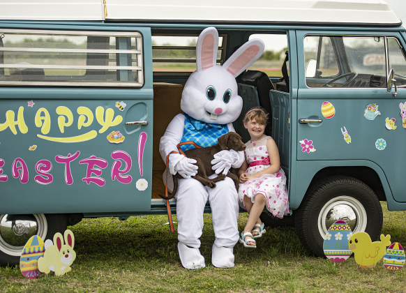 7-year-old Sawyer Latham and Barkley, her family's 4-month-old puppy,  get their photos taken with the Easter Bunny during the annual Easter egg hunt at Georgetown Church of the Nazarene on Saturday, March 30, 2024.   The vintage 1970 Volkswagen bus belongs to church member Clark Underwood, who restored the bus himself.