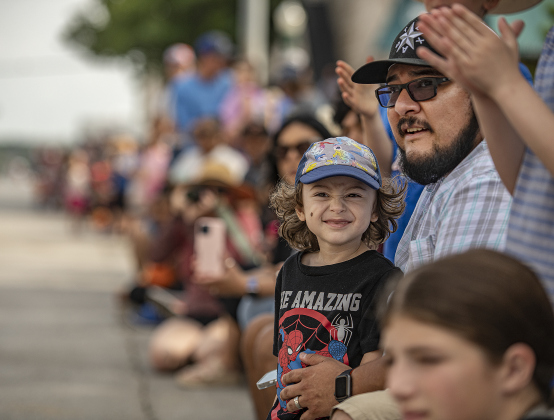 2-year-old Elliott Araiza, with his dad Bert Araiza, enjoyed watching the parade along Austin Avenue during the 25th Annual Red Poppy Festival on Saturday, April 27, 2024.    Photo by Andy Sharp. 