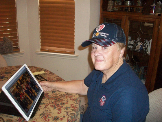 Frances “Fay” Pool, a 21-year Army veteran, enjoys reminiscing over photographs from her recent Honor Flight Austin trip to Washington, D.C., where Ms. Pool and other veterans visited many of the city’s monuments and memorials. The cap she’s wearing is from the Georgetown Rotary Foundation’s 2022 Field of Honor. (Photo by Brad Stutzman)