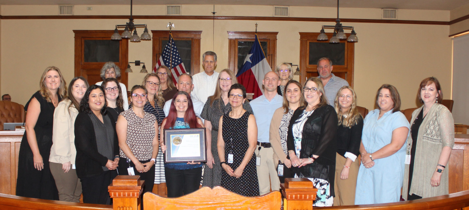 County Commissioners and Wilco’s Human Resources Department pose with Mental Health America’s 2024 Gold Bell Seal for Workplace Mental Health award during the June 18 Commissioners Court meeting.  Photo courtesy of Williamson County.